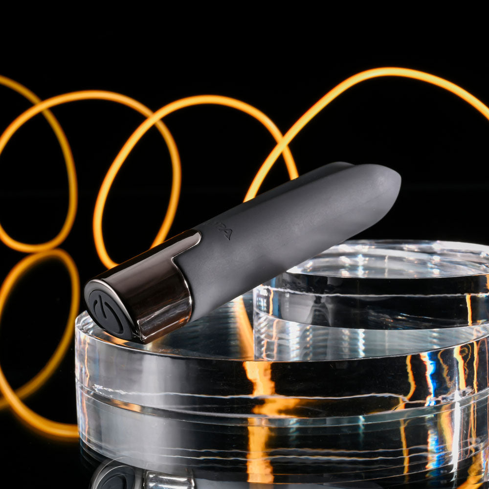 Selopa LITTLE BUDDY - 11.1 cm USB Rechargeable Vibrating Bullet on a glass surface with artistic lighting.