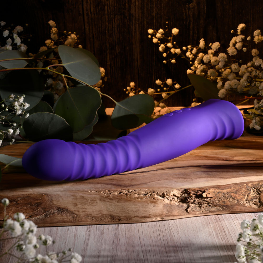 Selopa TRIXXXIE - 22.2 cm USB Rechargeable Vibrator on wooden surface with flowers.