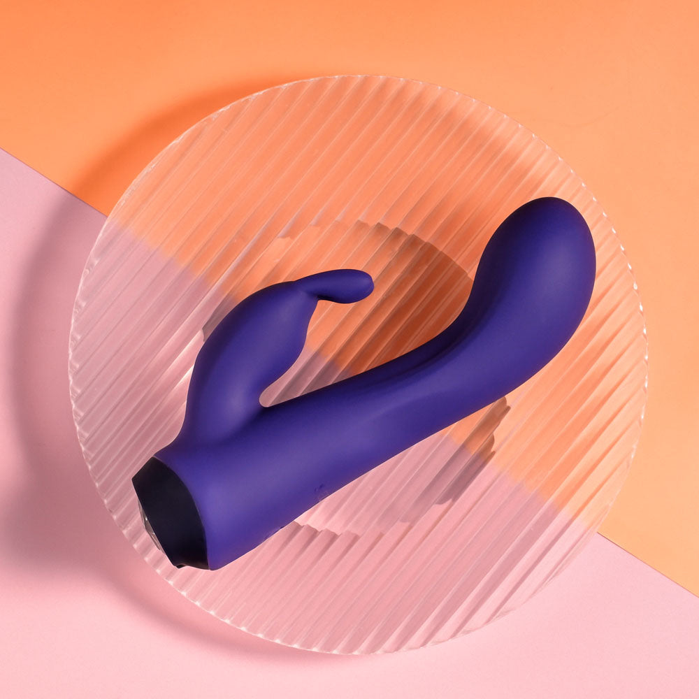 Selopa PLUM JOB - 13.5 cm USB Rechargeable Rabbit Vibrator displayed on a plate, showcasing its curved design and vibrant color.