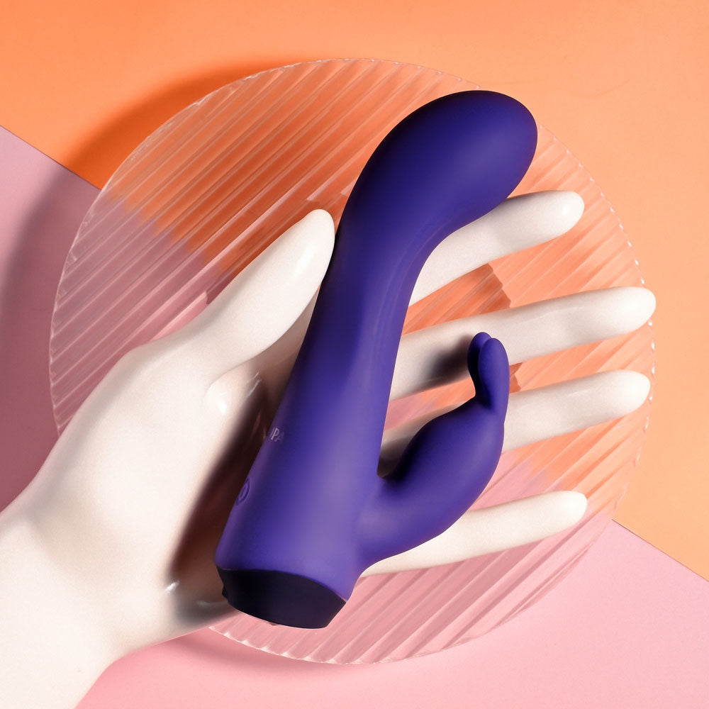Selopa PLUM JOB -  13.5 cm USB Rechargeable Rabbit Vibrator on a plate held by a hand.