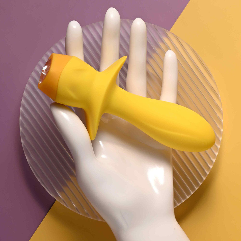 Selopa MELLOW  -  13.5 cm USB Rechargeable Vibrating Anal Plug on a hand against a colorful backdrop.