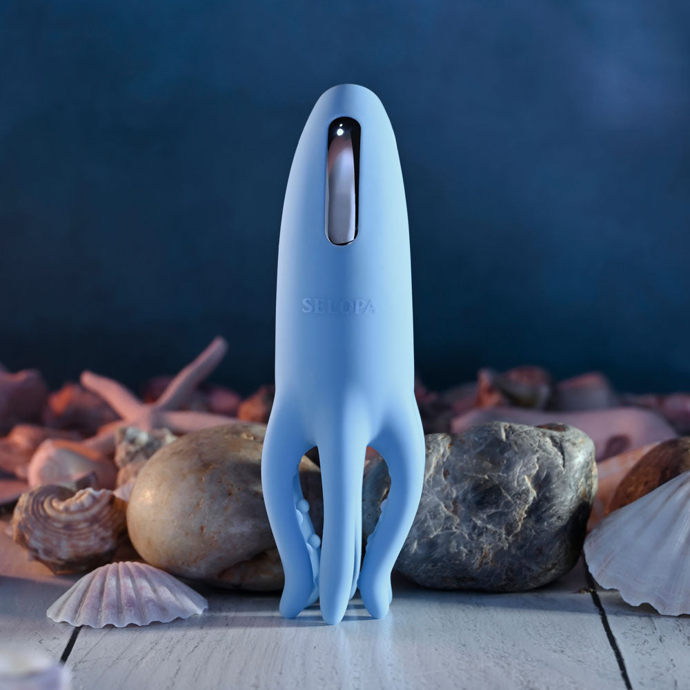 Selopa TENTACLE TICKLER - USB Rechargeable Vibrating Stimulator in soft blue silicone among seashells.