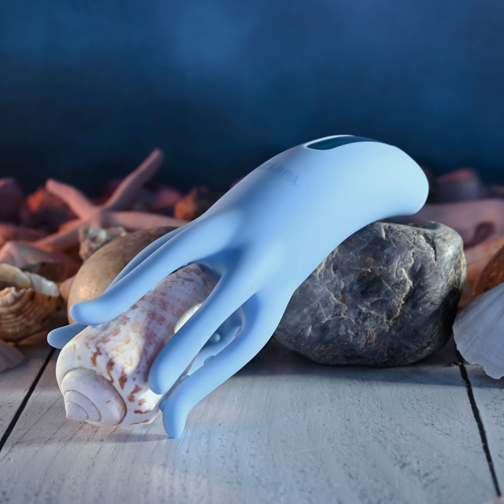 Selopa TENTACLE TICKLER -  USB Rechargeable Vibrating Stimulator on a rocky surface with seashells.