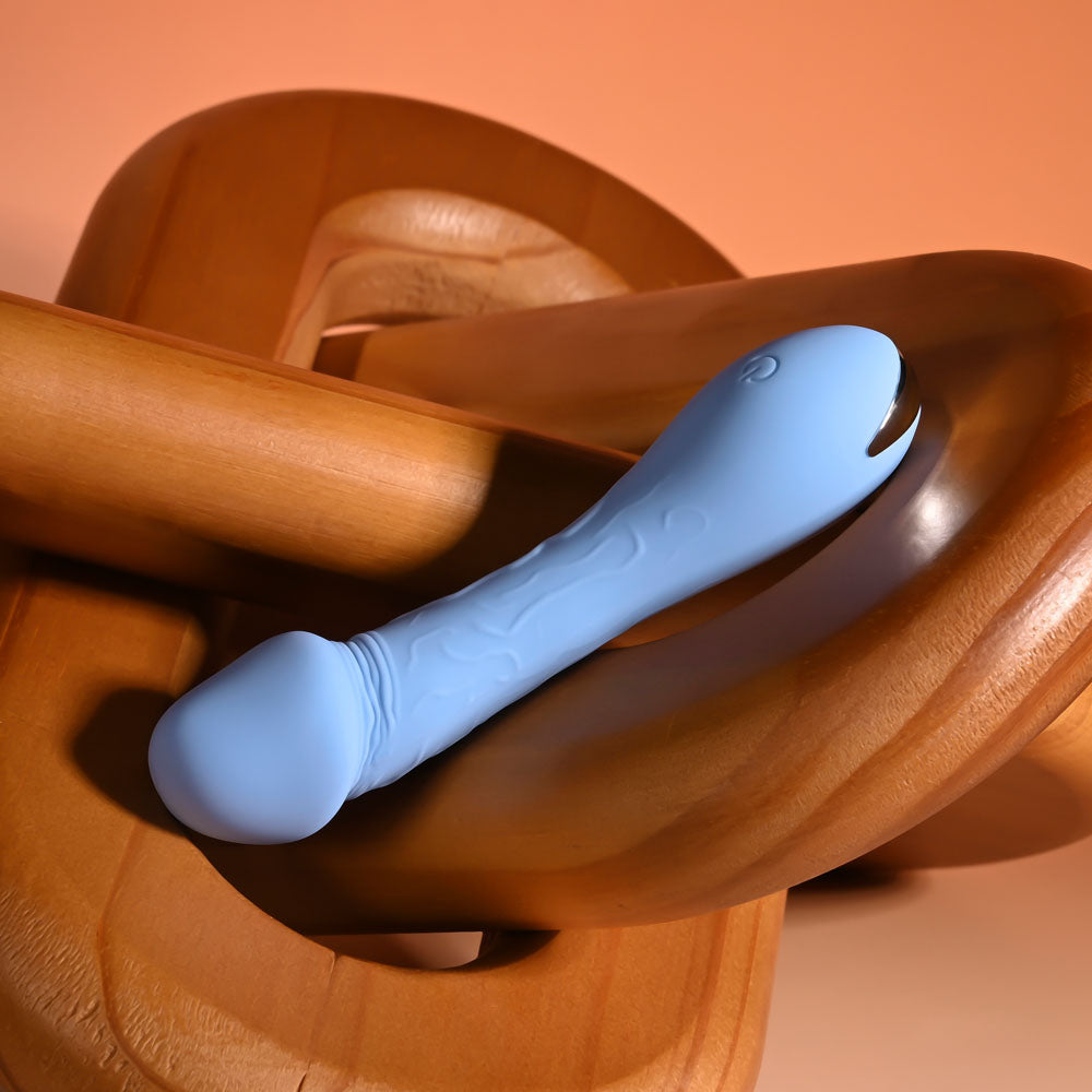 Selopa DAINTY DICK - Baby  11.9 cm USB Rechargeable Mini Vibrator on a wooden surface.
