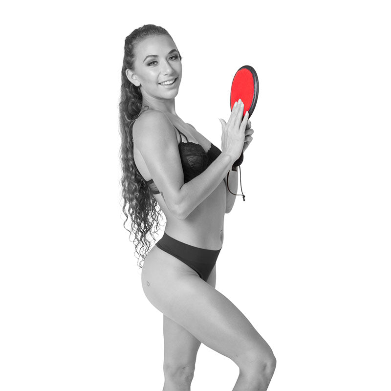 Sex & Mischief Amor Paddle - /Black Spanking Paddle held by a model in lingerie, highlighting its playful design.