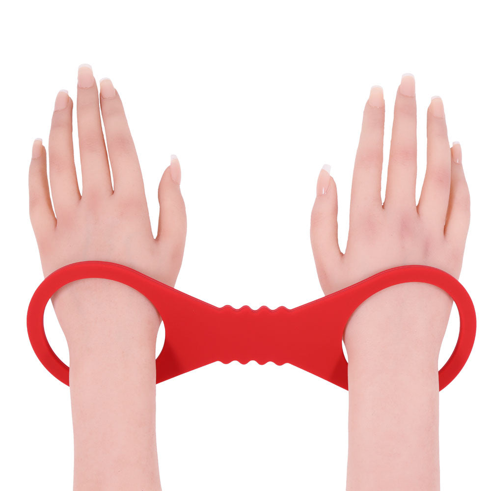 Sex & Mischief Amor Large Silicone Cuffs -  Large Restraints in passionate red holding wrists together.
