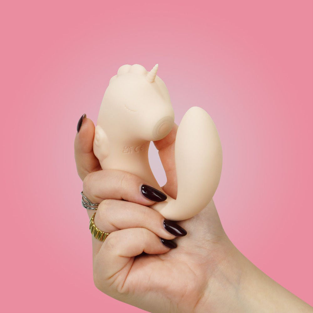 Unihorn - C Horse - Coral Throb - Coral USB Rechargeable Dual Unicorn Vibrator in hand on a pink background.