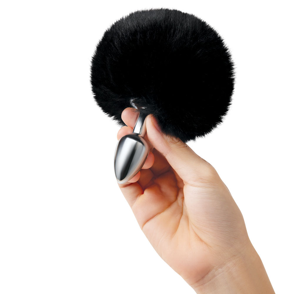 WhipSmart Furry Tales  Bunny Tail - Metal 6.3 cm Butt Plug with  Bunny Tail in hand, showcasing sleek design and playful attachment.