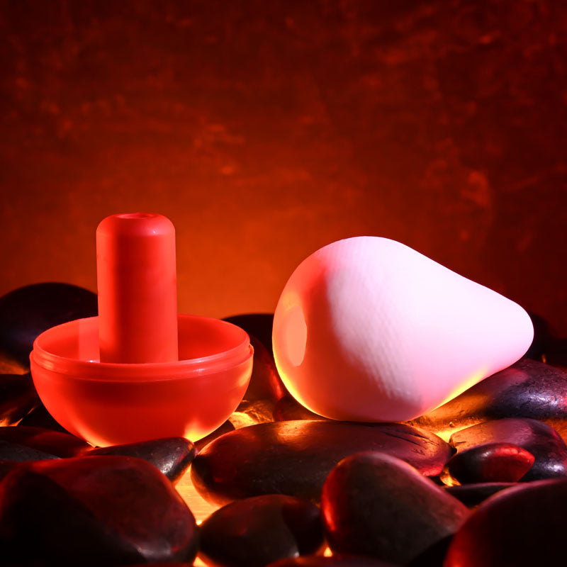 Zero Tolerance FUJI - Mini Stroker Egg resting on stones, showcasing its soft, squishy design for ultimate pleasure.