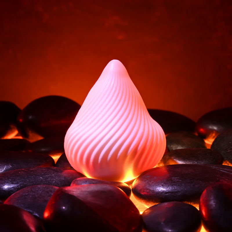 Zero Tolerance VESUVIUS -  Mini Stroker Egg on smooth stones, glowing softly for ultimate pleasure.