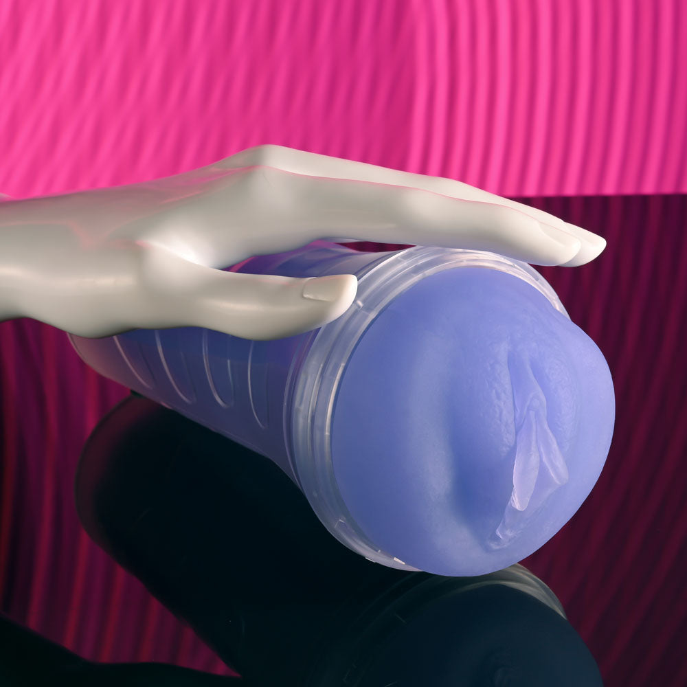 Zero Tolerance POP ON THE GLOW - Glow in Dark  Vagina Stroker with hand holding it on a glossy surface.