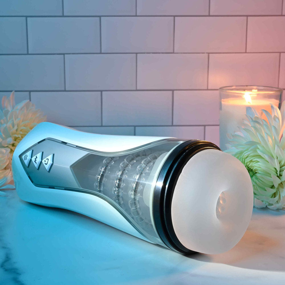 Zero Tolerance STROKING BUDDY - USB Rechargeable Vibrating & Thrusting Stroker on a marble surface, with candles and flowers.