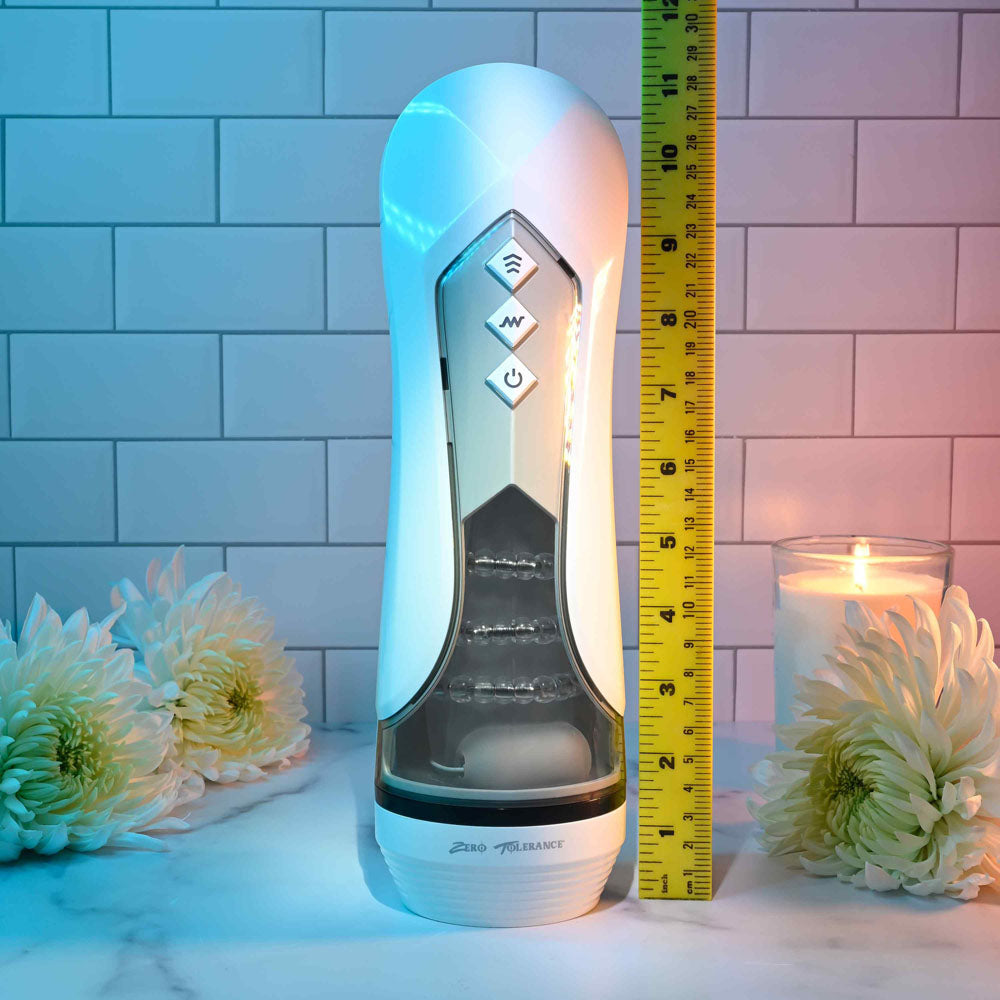Zero Tolerance STROKING BUDDY - USB Rechargeable Vibrating & Thrusting Stroker displayed with a measuring ruler and candles.