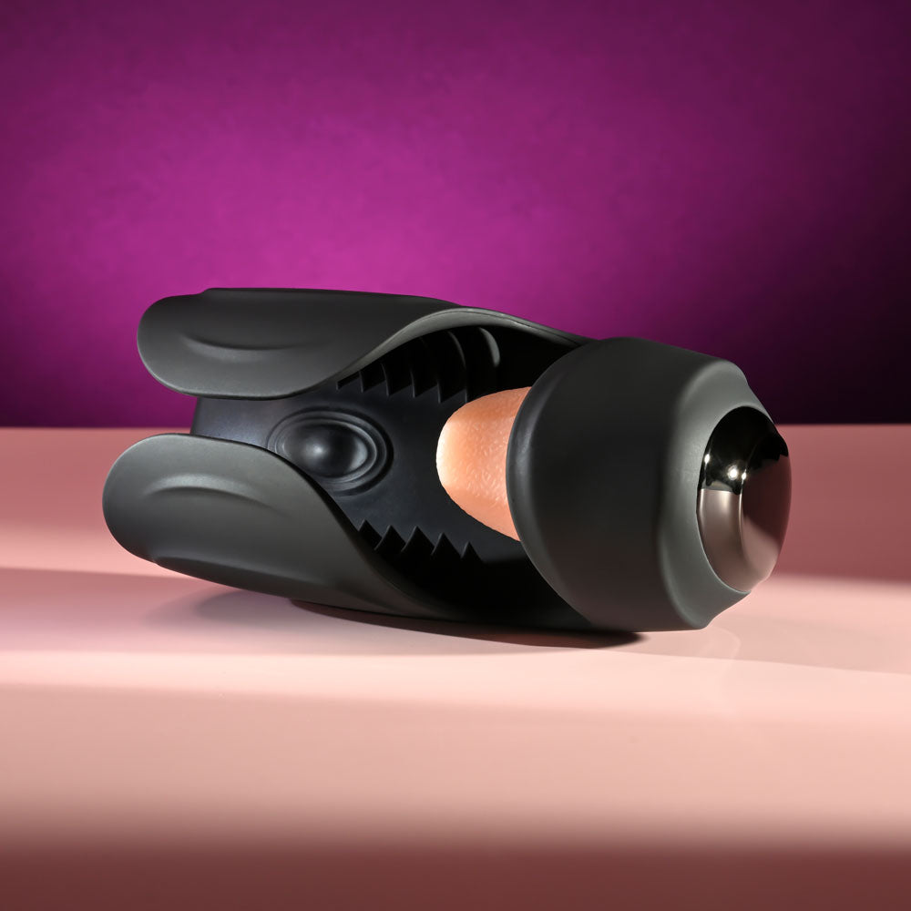 Zero Tolerance LICK THE TIP -  USB Rechargeable Vibrating & Flicking Masturbator on a pink surface.